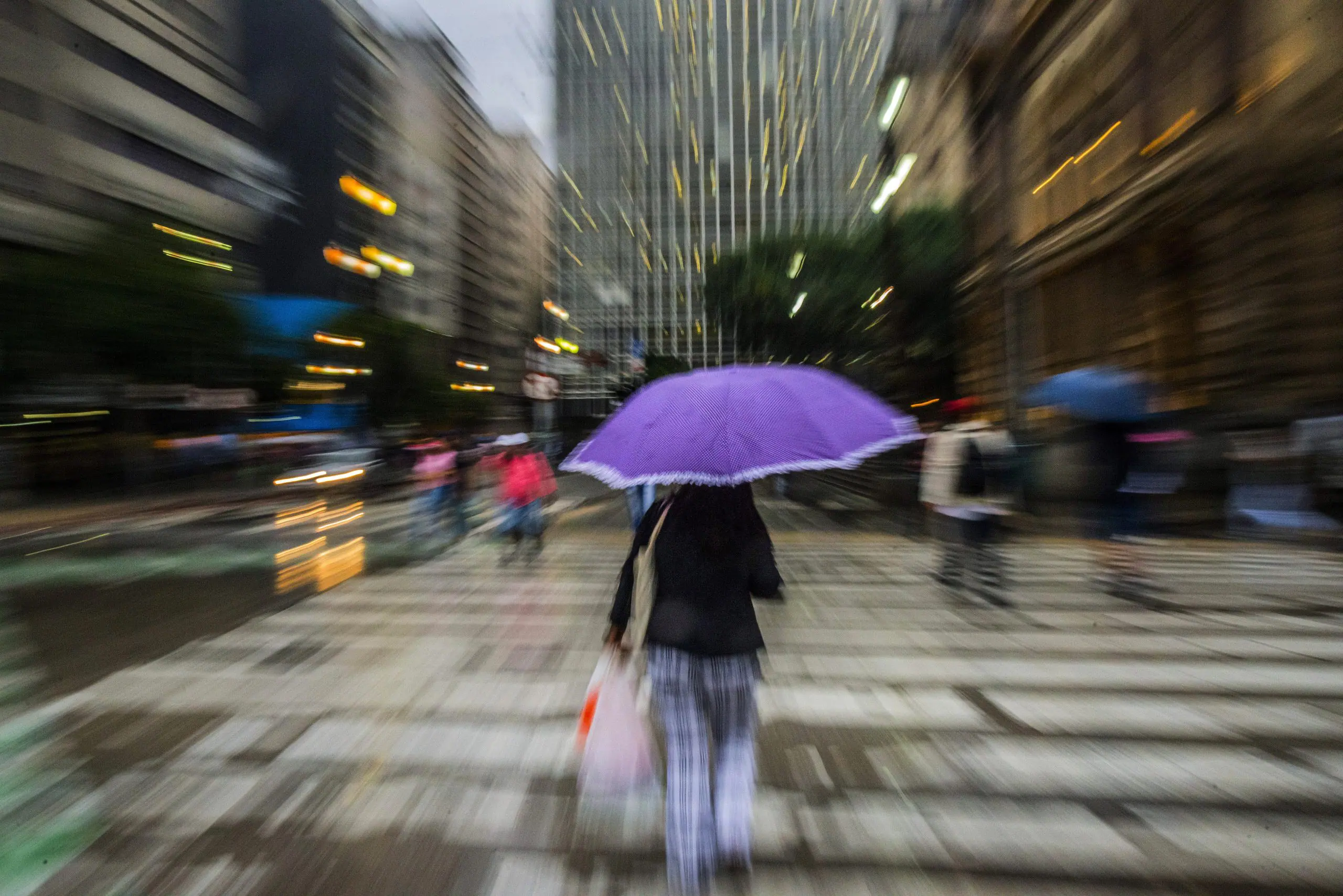 Pedestres se protegem da chuva no centro de São Paulo | Foto: Cris Faga/Estadão Conteúdo
