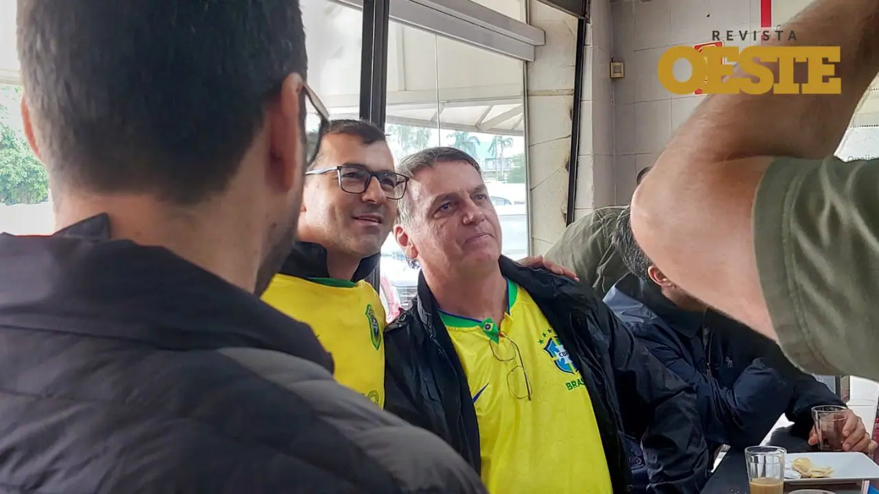 Bolsonaro de camisa amarela e blusa preta tira foto com apoiador