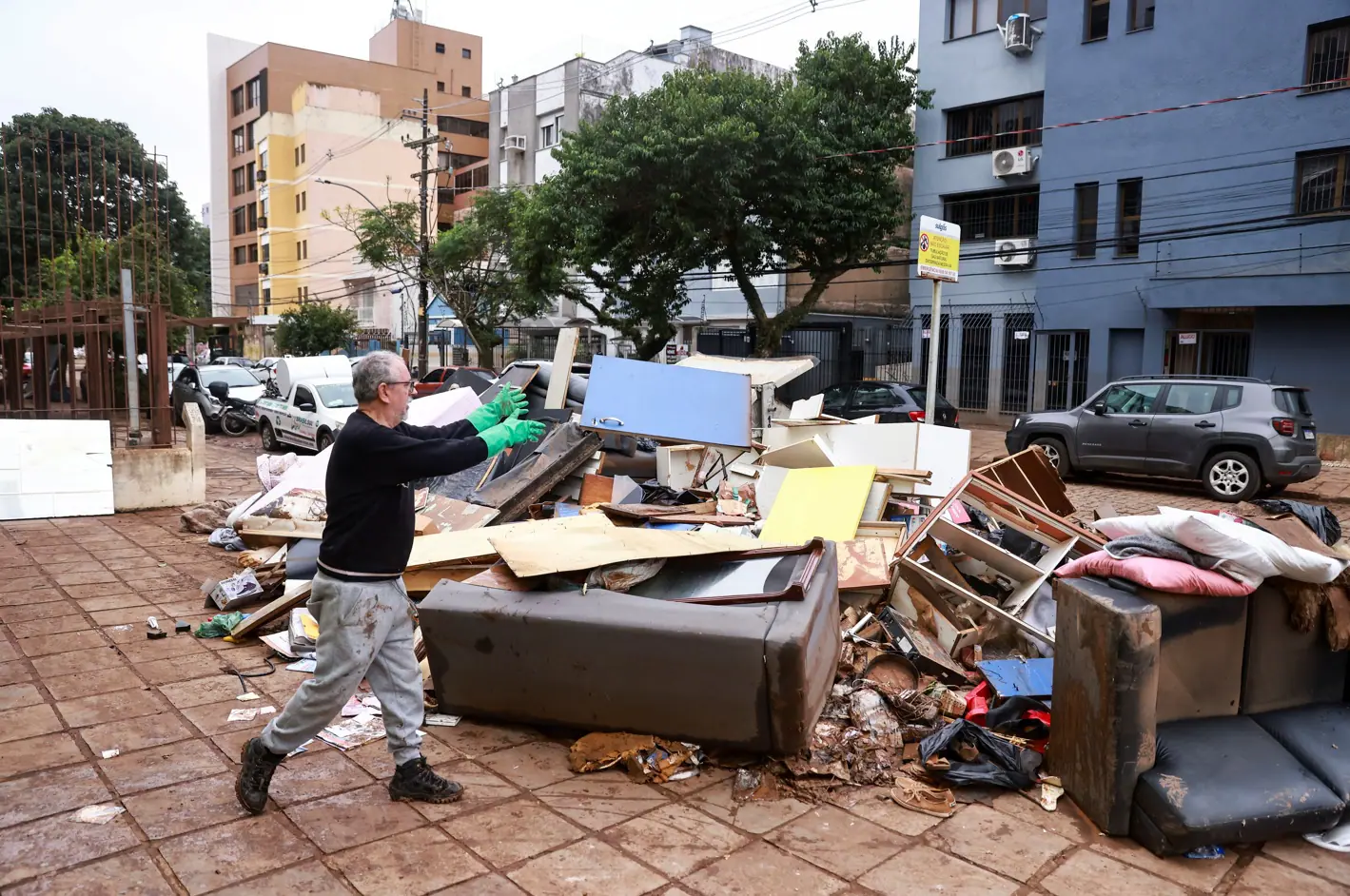 Um homem descarta objetos atingidos pela água em sua casa, depois das enchentes em Porto Alegre, Rio Grande do Sul - 20/5/2024 | Foto: Diego Vara/Reuters