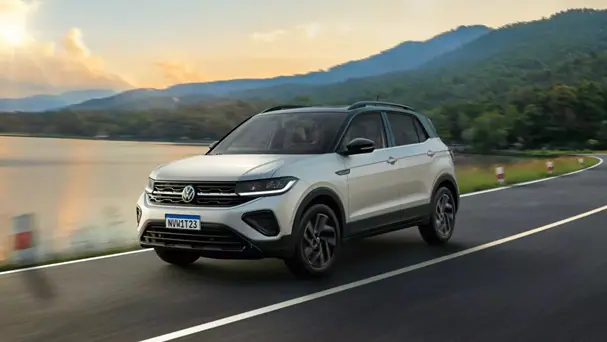 Carro da Volkswagen, T-Cross aparece em rua lisa, com montanhas e sol ao fundo