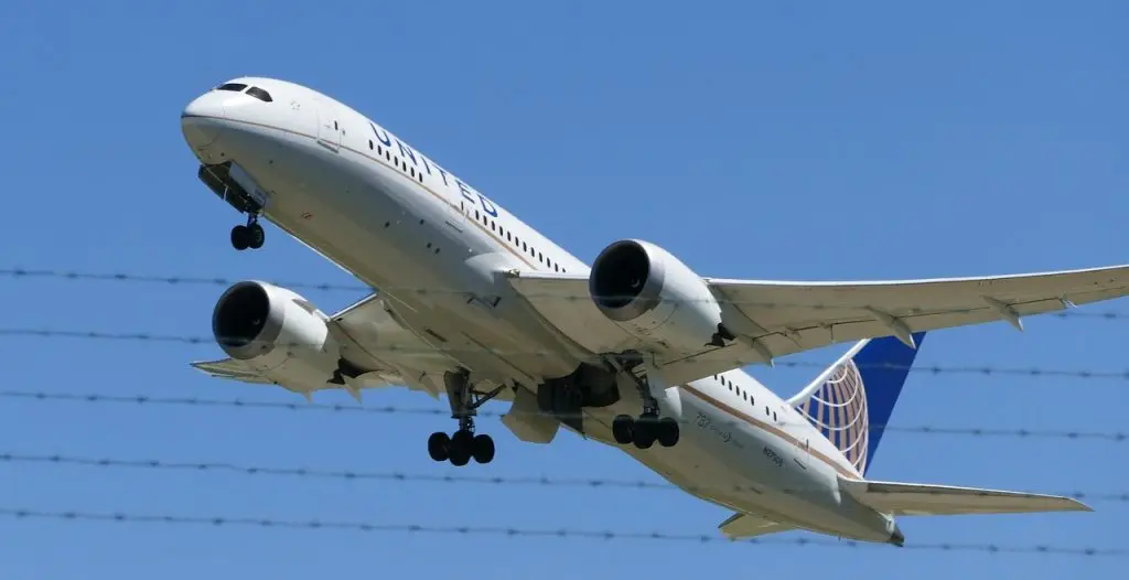Avião decolando e uma cerca de arame farpado