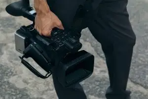 Pessoa carrega uma filmadora