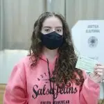 Jovem mostra o título de eleitor