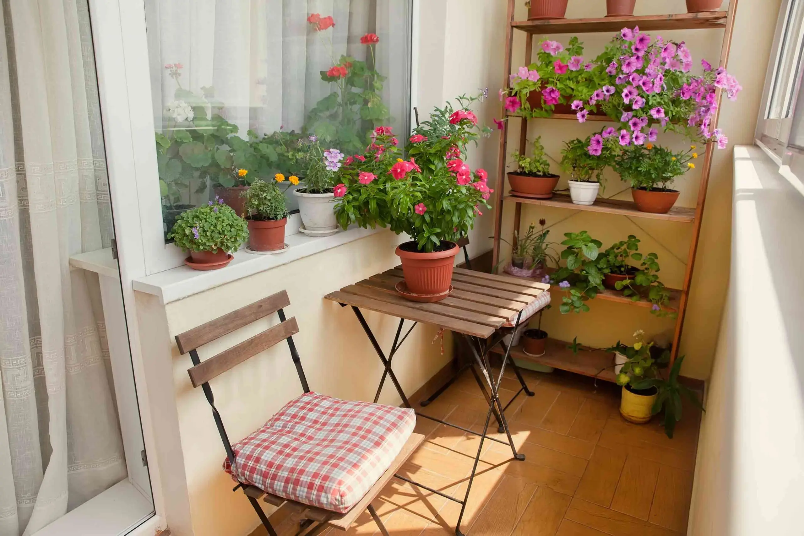 Varanda com pequena mesa, cadeira e flores ornamentais