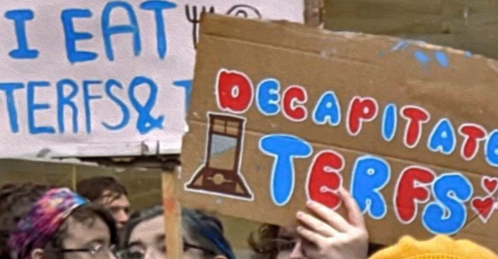 Manifestantes seguram cartazes com os dizeres "decapitem as TERFS" e "eu como TERFS..." durante protesto em Glasgow, Reino Unido