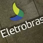 Fachada da empresa de energia Eletrobras. O logotipo é uma espécie de folha azul, verde claro e verde escuro, com o letreiro prateado