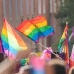 Pessoas na parada do orgulho com bandeiras LGBTIQ | Foto: Natalia de la Rubia/Shutterstock