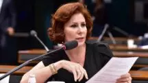 A deputada Carla Zambelli, durante uma sessão na Comissão de Constituição e Justiça da Câmara. Ela está de vestido preto, sentada, de frente para um microfone