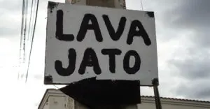 Placa fixada em poste de energia com a palavra escrita em português, LAVA JATO. LAVA JATO é uma operação da polícia brasileira para combater a corrupção