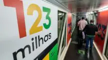 Imagem mostra o corredor de uma empresa, com uma das paredes exibindo, em letras garrafais, o logotipo da 123milhas, empresa que está em processo de recuperação judicial