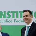 O presidente, Luiz Inácio Lula da Silva, e o presidente do Senado, Rodrigo Pacheco, posam para uma foto ao lado de uma faixa representando a constituição brasileira montada em frente ao Congresso Nacional, durante o evento que marca um ano do 8 de janeiro, em Brasília | Foto: Reuters/Adriano Machado