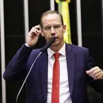 Ricardo Cappelli, vestido de terno preto, camisa branca e gravata vermelha, durante discurso na Câmara dos Deputados
