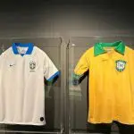 fifa extrema direita seleção | Em uma das salas, há uma camisa branca com detalhes em azul, de 2019, e a outra verde e amarela dos anos 1950 | Foto: Reprodução/Fifa