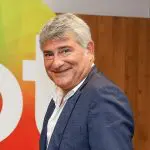 Foto do narrador Cléber Machado ao lado do logo do SBT