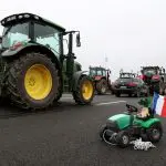 Uma marionete, que somboliza a agricultura de beterraba sacarina, senta-se em um trator de brinquedo, durante um bloqueio feito por agricultores na Rodovia A4, para protestar contra pressões de preços, impostos e regulamentação verde