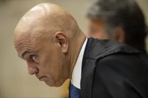 O ministro Alexandre de Moraes, de perfil, olha para baixo, com os olhos bem abertos, e expressão de preocupação
