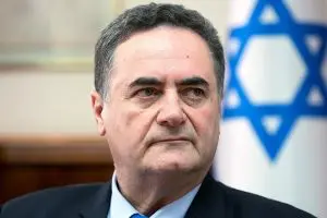 Israel Katz, ministro das Relações Exteriores de Israel, olhando de frente para a câmera. Atrás, uma bandeira de Israel