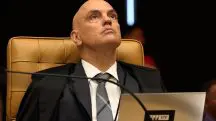 Indivíduo sério em tribunal, vestido com toga preta e gravata listrada, associado a Alexandre de Moraes
