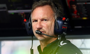 Christian Horner, chefe de equipe da Red Bull Racing, da Fórmula 1, com fone de ouvido, camiseta polo da equipe e expressão séria.