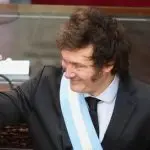 Javier Milei durante discurso no Congresso Argentino. O Executivo está com o braço levantado e sorrindo