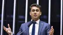 Nikolas Ferreira veste terno cinza e camisa branca durante discurso