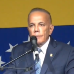 Manuel Rosales com bandeira da Venezuela no fundo