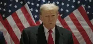 Donald Trump durante discurso com a bandeira do EUA atrás