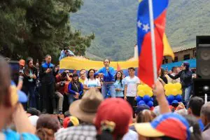 Maria Corina Machado veste uma roupa azul enquanto discursa para eleitores venezuelanos