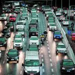 A imagem ilustra um movimento de carros em uma avenida brasileira. Todos devem pagar IPVA