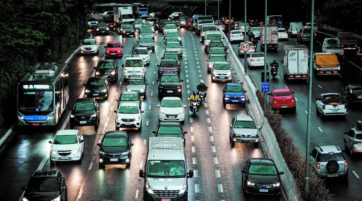A imagem ilustra um movimento de carros em uma avenida brasileira. Todos devem pagar IPVA
