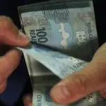 Mãos contam notas de dinheiro