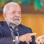 Lula, de terno preto, durante conversa com jornalistas no Palácio da Alvorada
