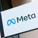 Foto de um banner branco, com o logo da Meta. As letras estão em preto, e o símbolo da empresa em azul.