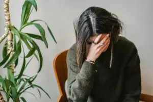 Jovem triste com a cabeça baixa