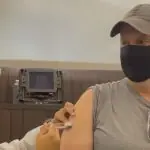 Foto do ex-jogador Tande se vacinando