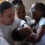 padre dá puxão em criança durante batismo