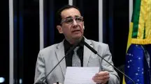 Jorge Kajuru veste terno cinza, camisa social preta, gravata cinza, óculos e segura papel durante discurso no Plenário