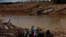 Pessoas caminham perto de uma ponte que desabou durante a cheia do Rio Taquari, em Arroio do Meio, no Rio Grande do Sul - 20/5/2024 | Foto: Amanda Perobelli/Reuters