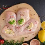 Filé de frango cru, com alho, pimenta e alecrim na madeira na tábua | Foto: Reprodução/Freepik
