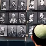 Um visitante olha para fotos de vítimas do Holocasto, no Museu de História do Holocausto Yad Vashem, em Jerusalém - 18/4/2012 | Nir Elias/Reuters