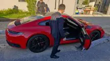 Porsche vermelha sendo inspecionada por um oficial