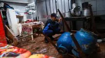 Evandir Severo dos Santos limpa seu restaurante, que ficou parcialmente destruído, depois das enchentes em Porto Alegre