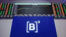 Gráfico do Ibovespa atrás de uma placa do B3, a Bolsa de Valores do Brasil