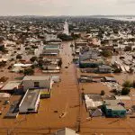 Em barcos, voluntários buscam pessoas isoladas no bairro inundado de Mathias Velho, em Canoas, Rio Grande do Sul - 5/5/2024 | Foto: Amanda Perobelli/Reuters