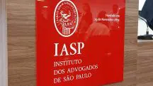 Placa com a logo e o nome do IASP com um fundo vermelho