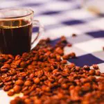 Xícara de café com grãos na mesa
