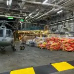 Foto mostra depósito com helicóptero da Marinha e doações para o Rio Grande do Sul