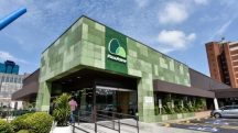 Fachada de uma unidade do Grupo Pão de Açúcar; loja está aberta, e um cliente, de costas, aparece na imagem