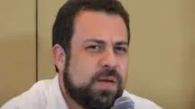 Guilherme Boulos, de camisa branca, aparece com semblante de alguém preocupado durante uma entrevista transmitida pelo canal de Luiz Inácio Lula da Silva no YouTube