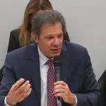 Imagem mostra o ministro Fernando Haddad gesticulando enquanto fala em audiência na Câmara dos Deputados